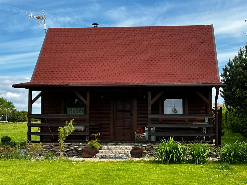 a log cabin with a red roof at Domek u Karkonosza in Kamienna Góra