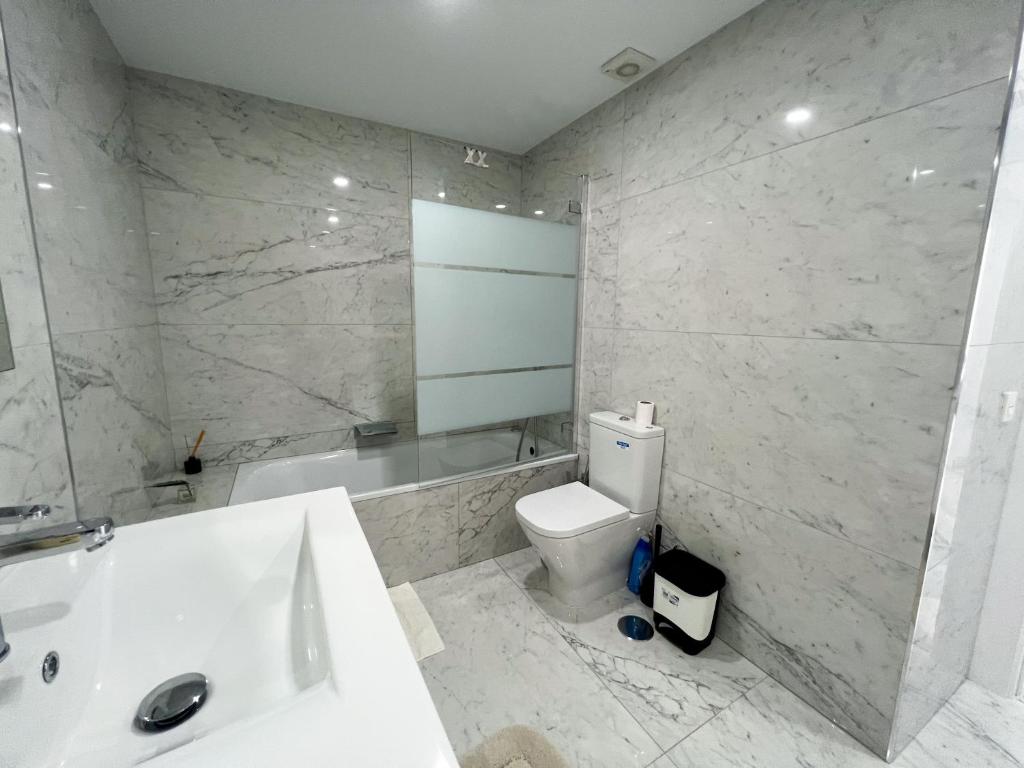 łazienka z umywalką, toaletą i wanną w obiekcie Luxury three bedroom apartment at Estepona w mieście Estepona