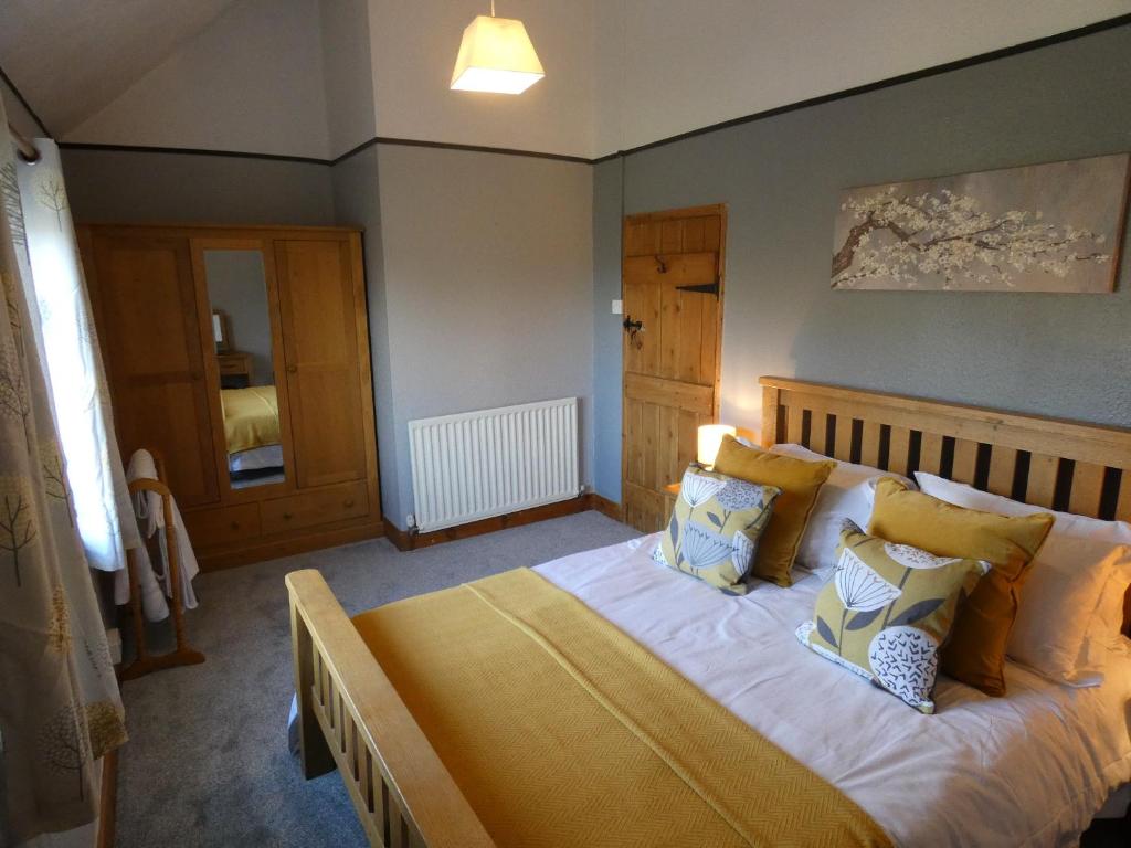a bedroom with a bed with yellow and blue pillows at Shepherds Cottage in Shrewsbury