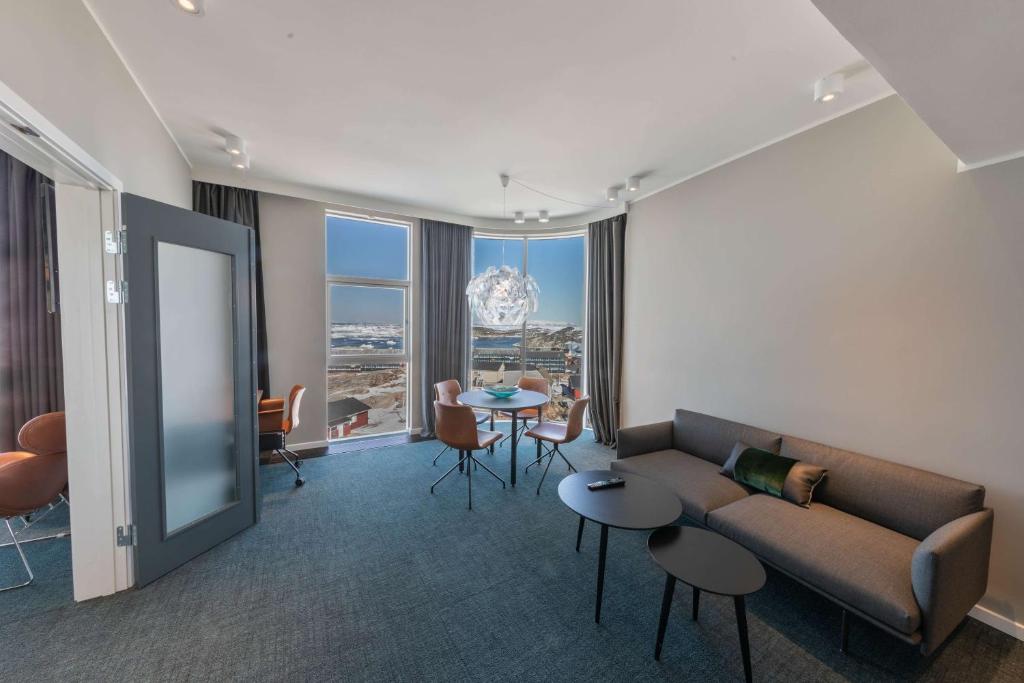 a living room with a couch and a table at Best Western Plus Hotel Ilulissat in Ilulissat