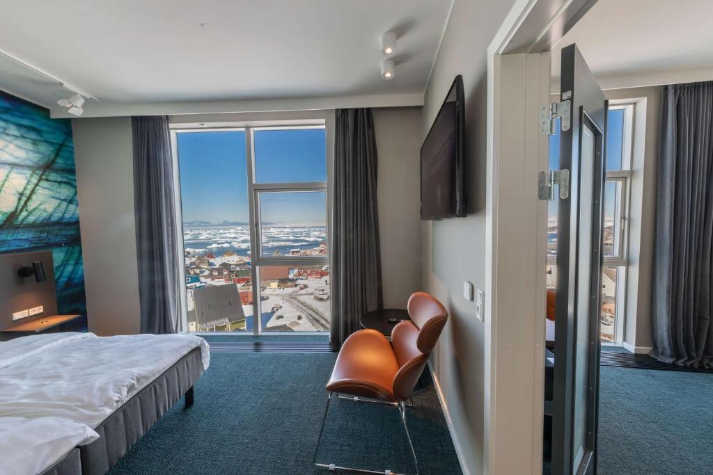 a hotel room with a bed and a large window at Best Western Plus Hotel Ilulissat in Ilulissat