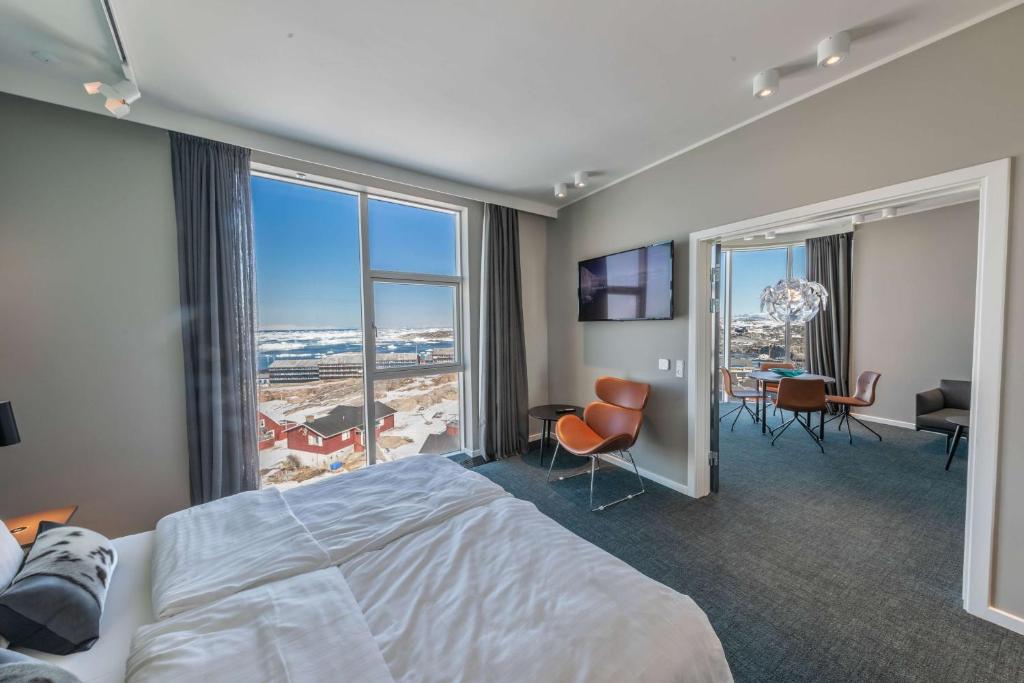 a hotel room with a bed and a large window at Best Western Plus Hotel Ilulissat in Ilulissat