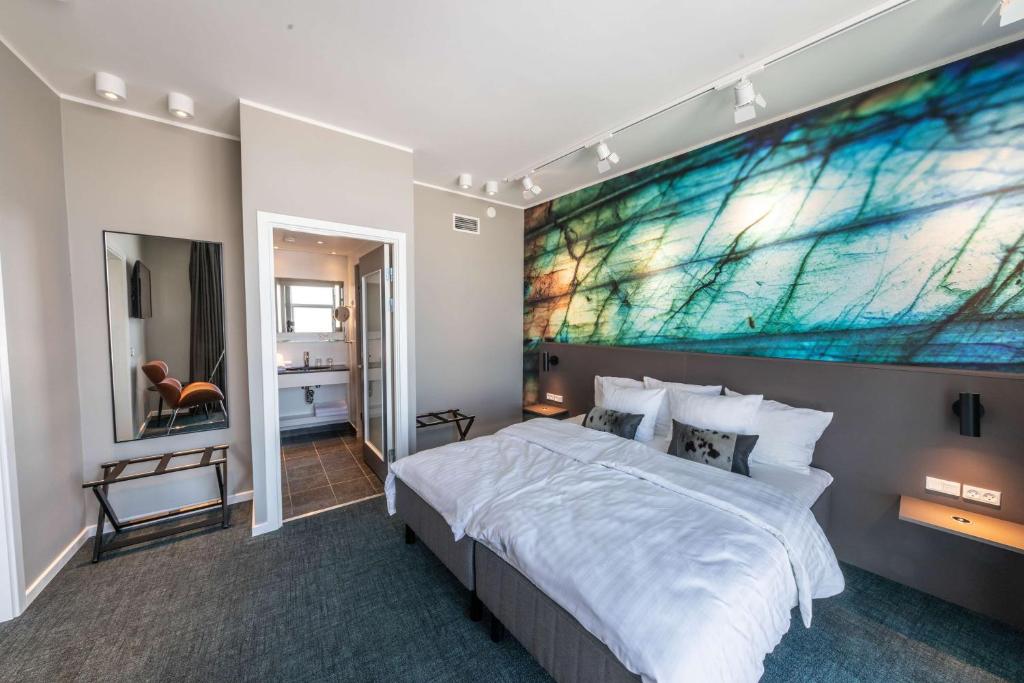 a bedroom with a large painting above the bed at Best Western Plus Hotel Ilulissat in Ilulissat
