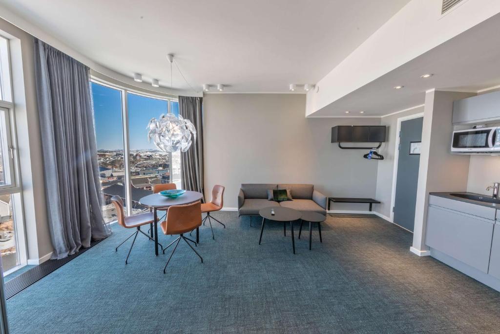 a kitchen and living room with a table and chairs at Best Western Plus Hotel Ilulissat in Ilulissat