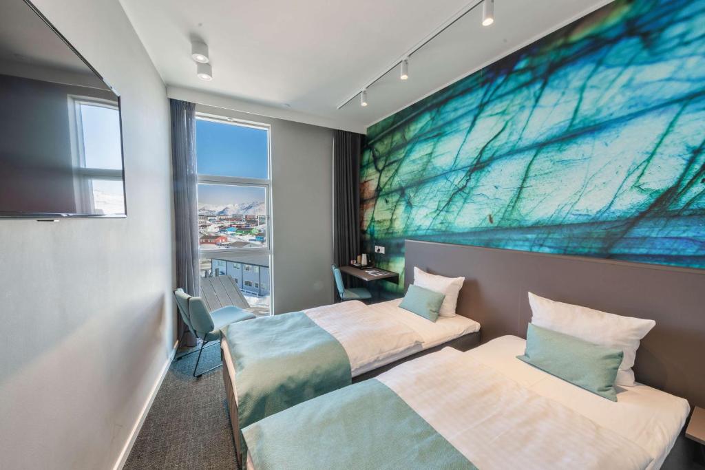 two beds in a room with a large painting on the wall at Best Western Plus Hotel Ilulissat in Ilulissat