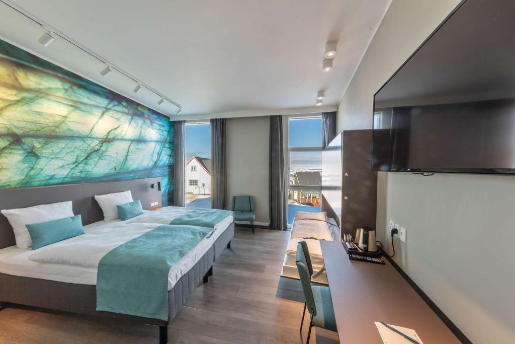 a hotel room with a large bed and a tv at Best Western Plus Hotel Ilulissat in Ilulissat