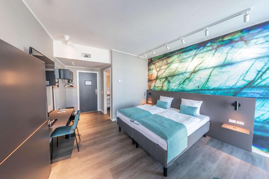 a bedroom with a bed with a painting on the wall at Best Western Plus Hotel Ilulissat in Ilulissat