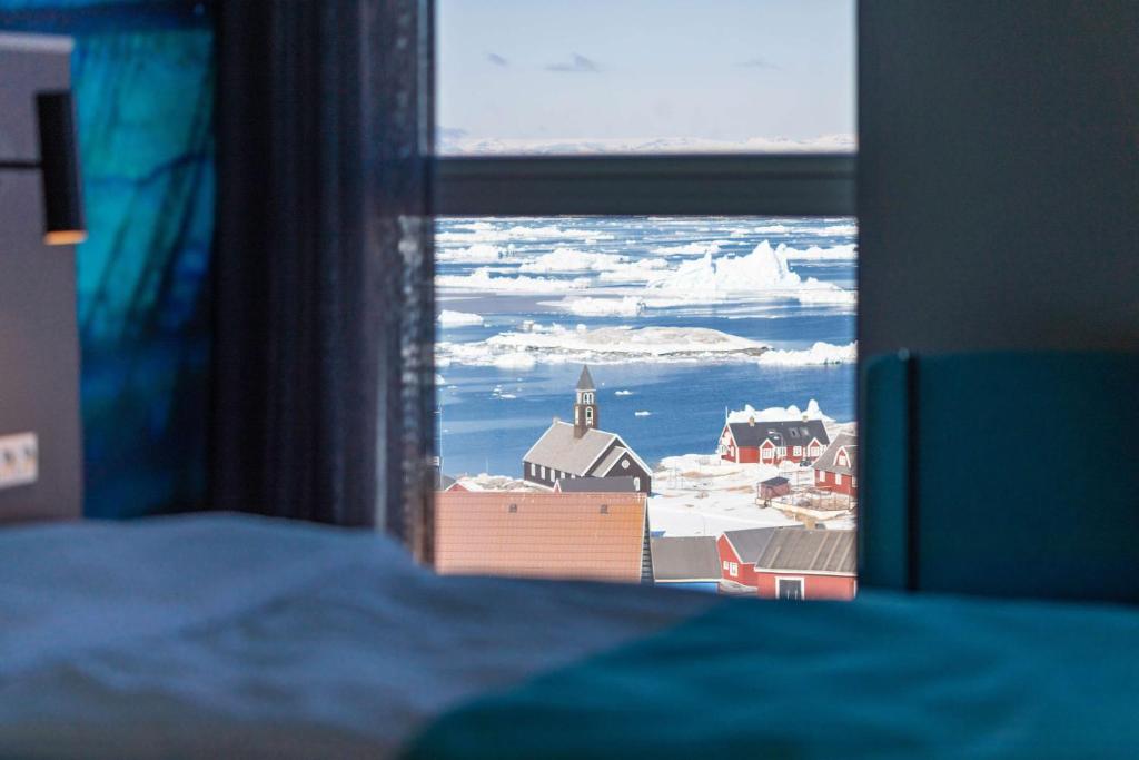 a view of a town from a bedroom window at Best Western Plus Hotel Ilulissat in Ilulissat