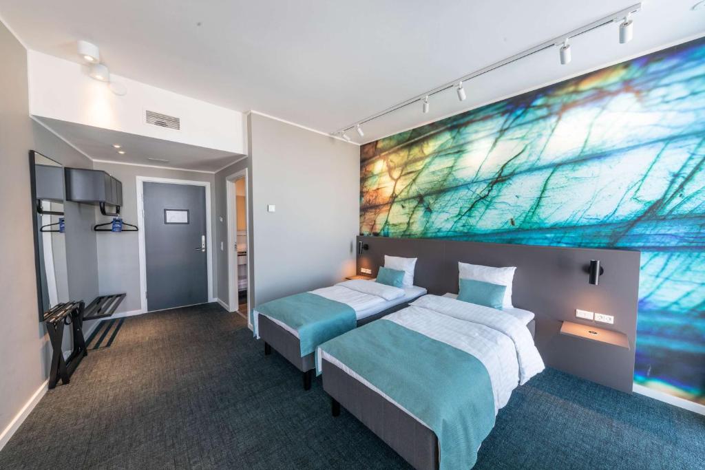 a bedroom with a bed and a large painting on the wall at Best Western Plus Hotel Ilulissat in Ilulissat