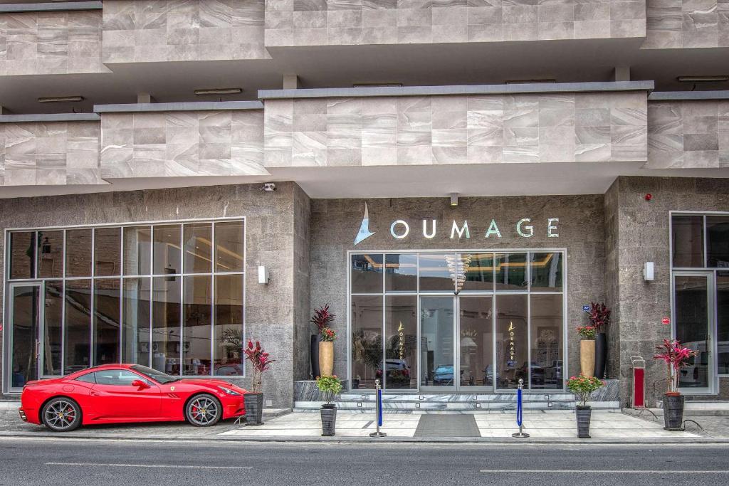 ein rotes Auto, das vor einem Geschäft parkt in der Unterkunft Loumage Suites and Spa in Manama