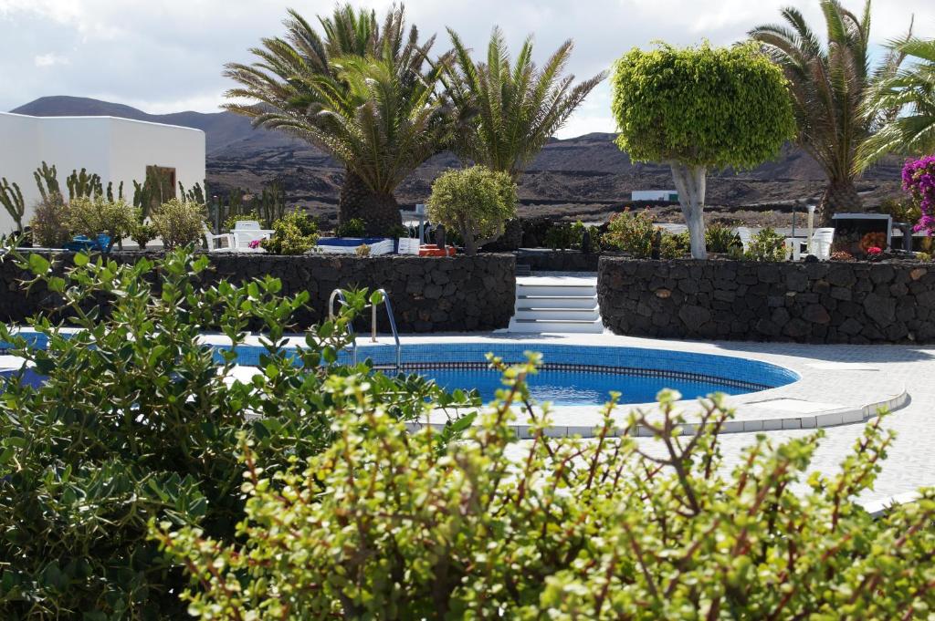 a resort with two swimming pools and palm trees at Apartments Casa Blanca in Charco del Palo