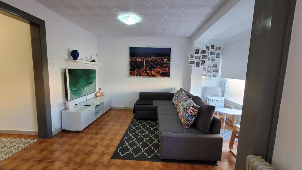 sala de estar con sofá y TV en APARTAMENTS B O D CoLLBLANC, en Hospitalet de Llobregat