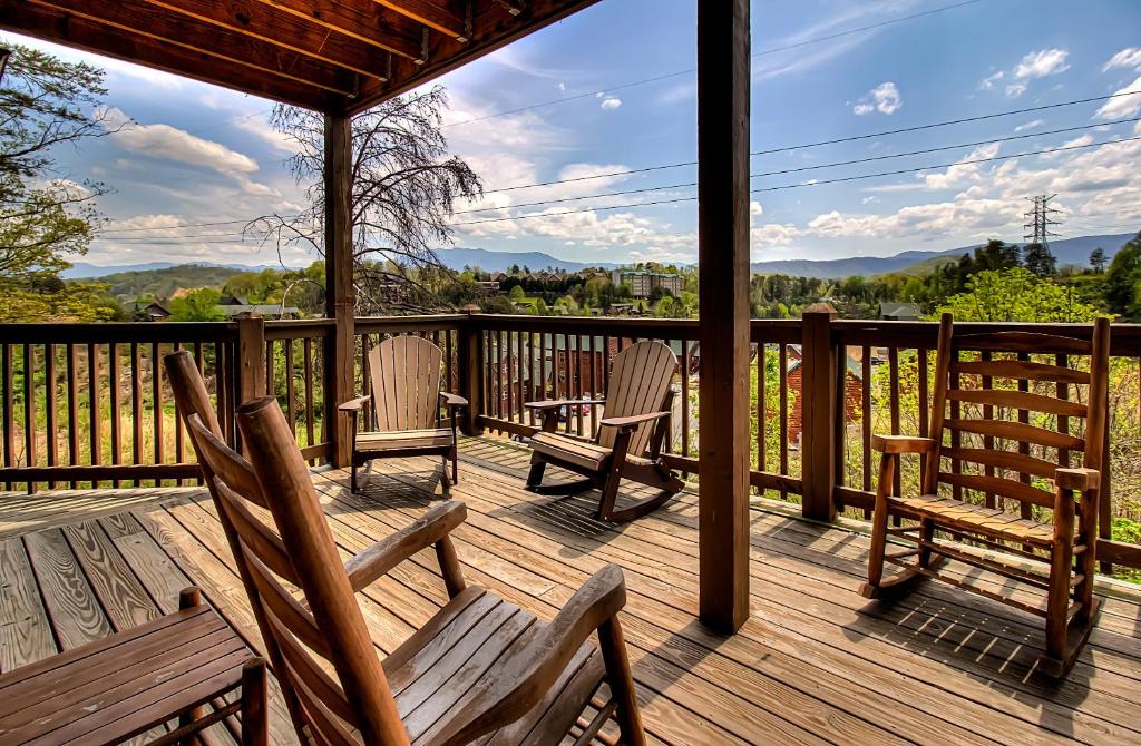 a porch with rocking chairs and a view of the mountains at Bear Cove Falls #4133 in Pigeon Forge