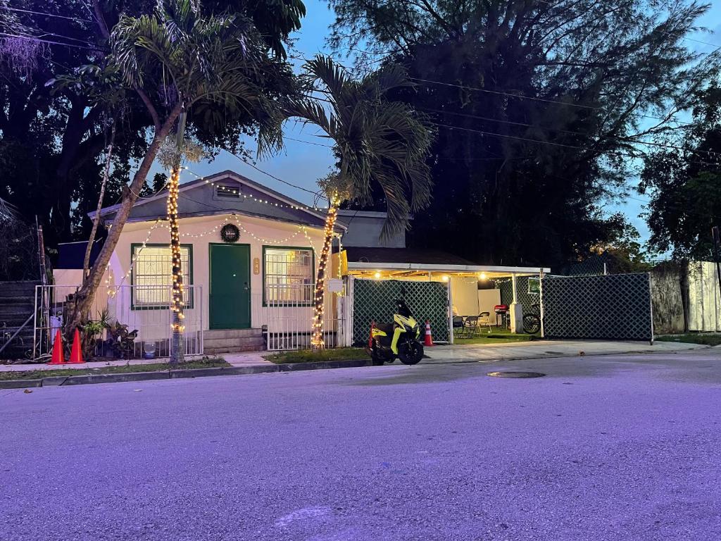 un ciclomotor estacionado frente a una casa con luces en OQP Vacations Miami en Miami