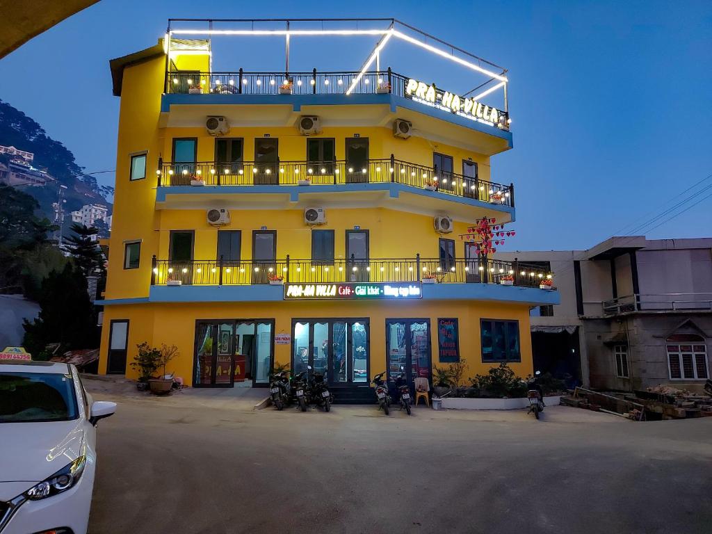 a yellow building with a balcony on top of it at Pra-Ha Villa in Tam Ðảo