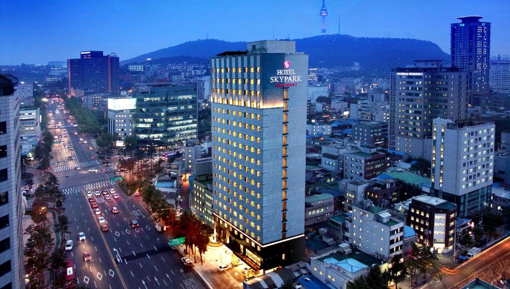 een hoog gebouw met een bord erop in een stad bij Hotel Skypark Dongdaemun I in Seoul