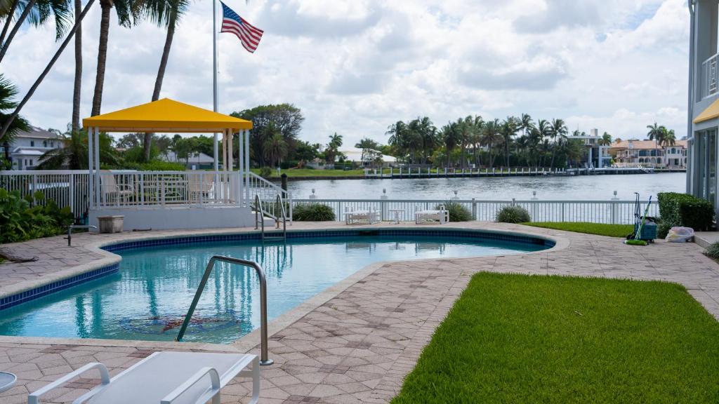 a swimming pool with an american flag and a body of water at WaterFront 4BR 3B,Intercoastal,Pool,5 min walk to beach-7 in Fort Lauderdale