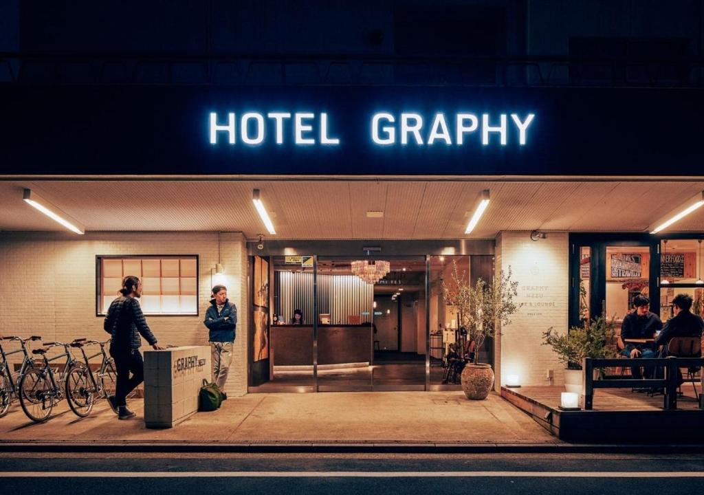 a woman standing outside of a hotel grry at Hotel Graphy Nezu in Tokyo