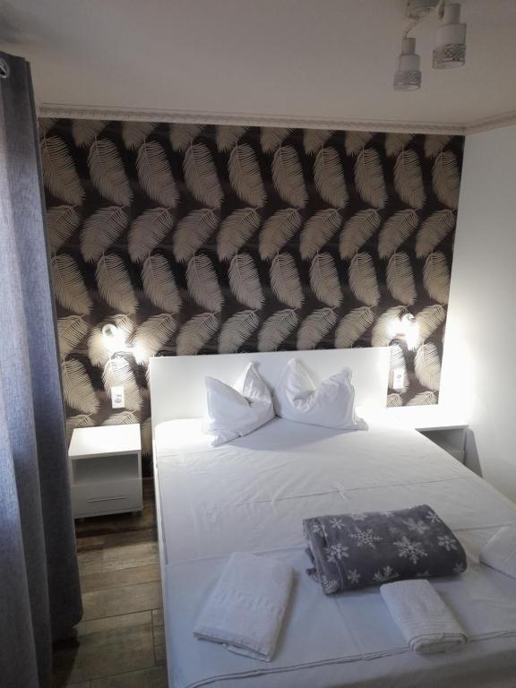 una camera con un letto bianco e una grande testiera del letto di R i A N A 3 a Eforie Sud