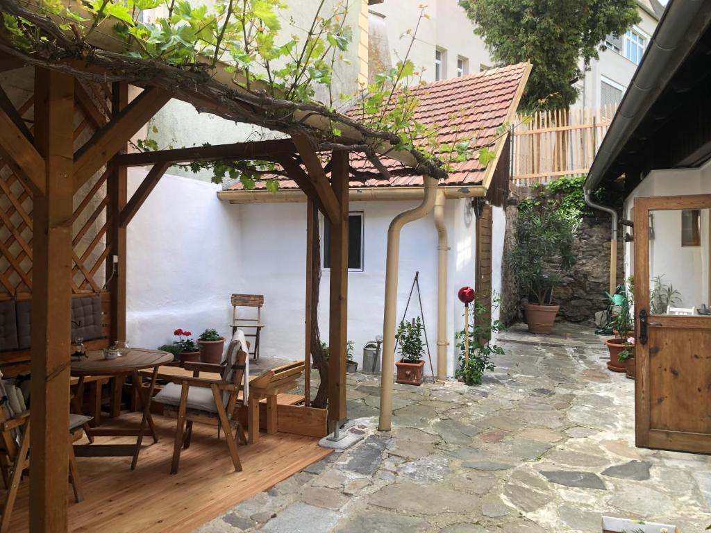 eine Außenterrasse mit einem Tisch und Stühlen in der Unterkunft APARTMENT ZUM ROTEN TOR in Spitz