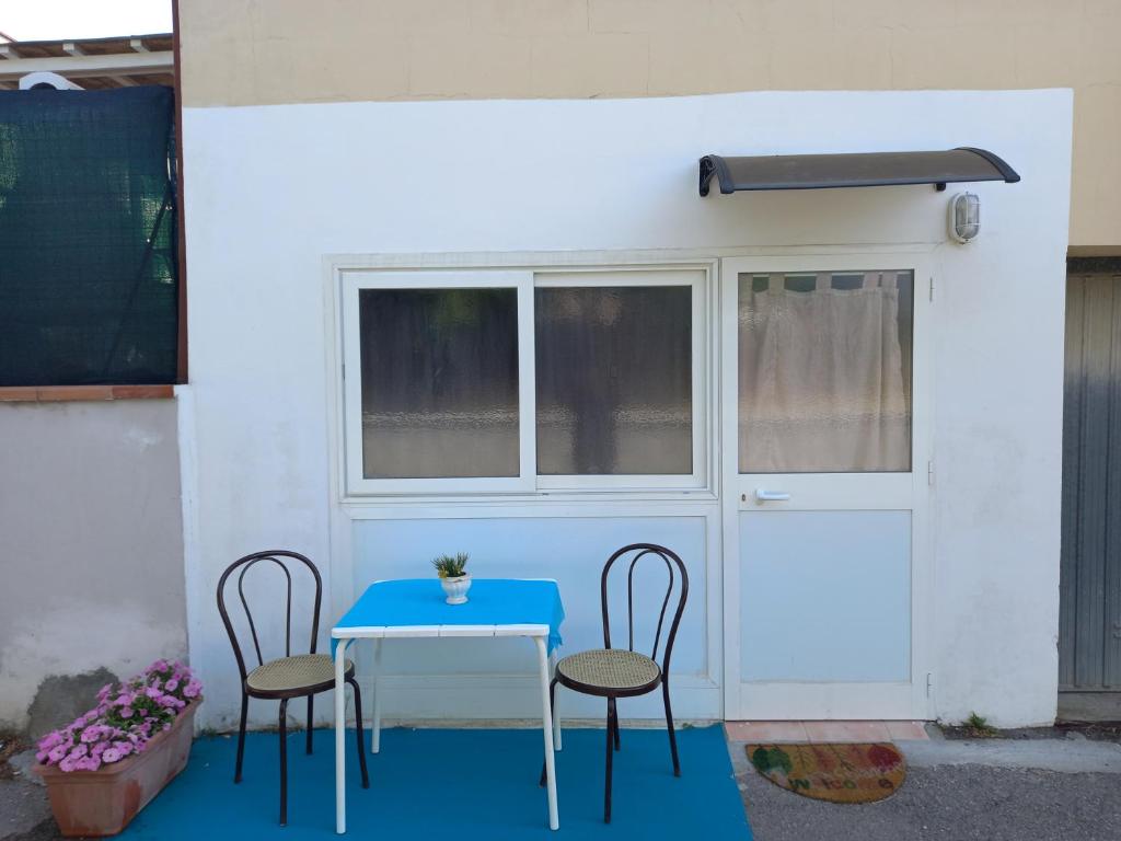 una mesa y sillas frente a una puerta en White room, en Fucecchio