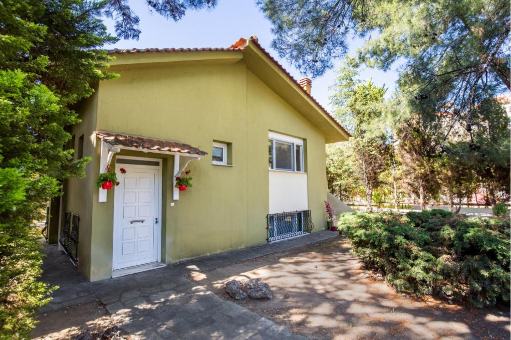 une petite maison jaune avec une porte blanche dans l'établissement BELUGA HOUSE, à Skala Rachoniou