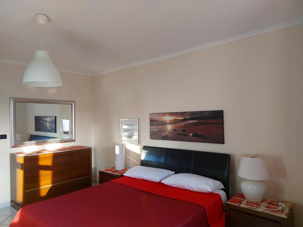 una camera con un letto rosso e un dipinto sul muro di Casa Relax a Porto Cesareo