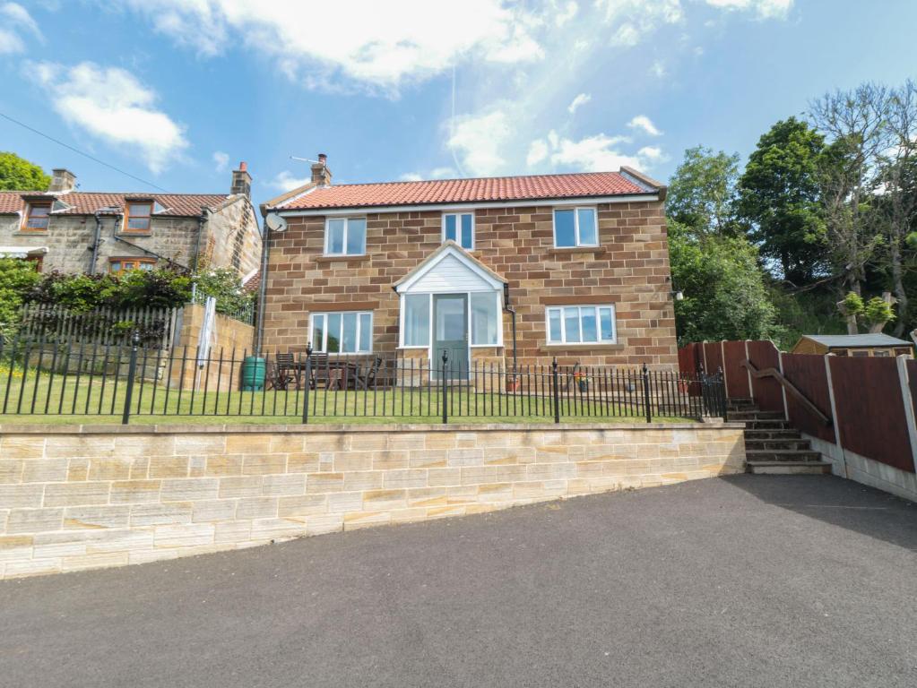 a brick house with a fence in front of it at Cherry Garth in Whitby