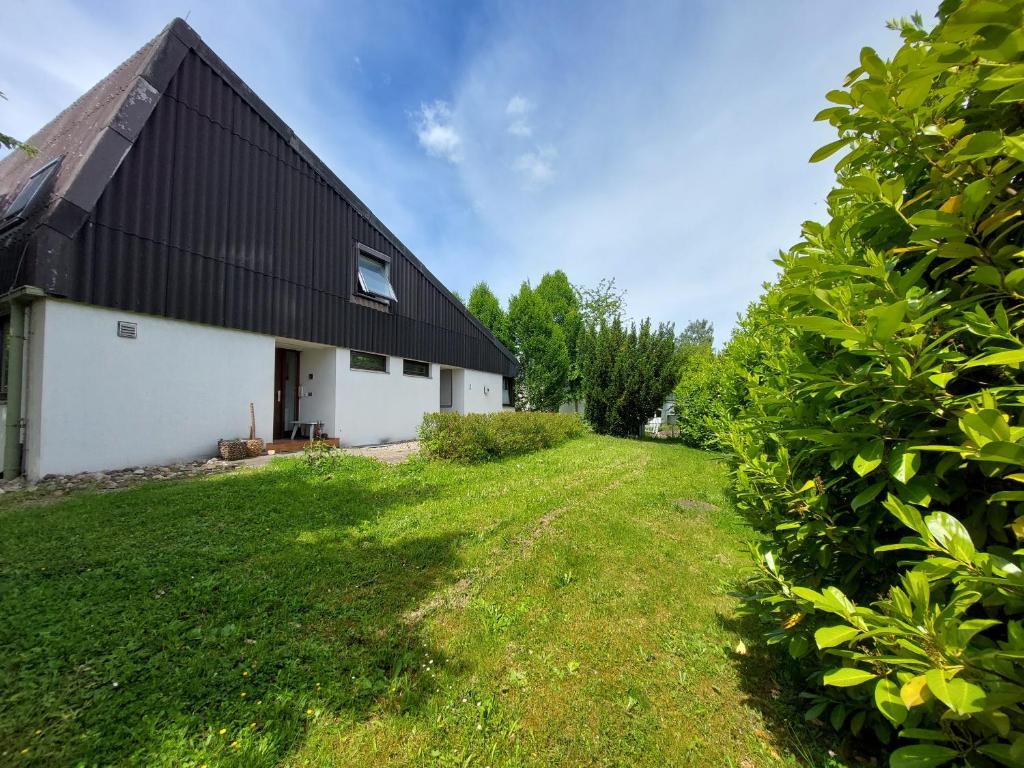 ein Haus mit einem schwarzen Dach und einem grünen Hof in der Unterkunft Pension beim Kastell in Sulz am Neckar