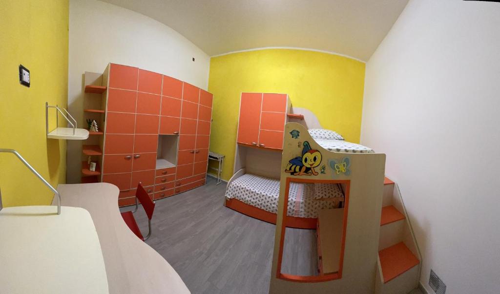 pokój z 2 łóżkami piętrowymi w pokoju z żółtym w obiekcie CASA DI KEKKO w mieście Mesagne