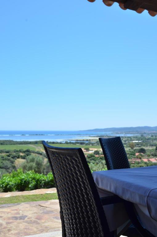 a table and chairs with a view of the ocean at La Minditta in San Teodoro