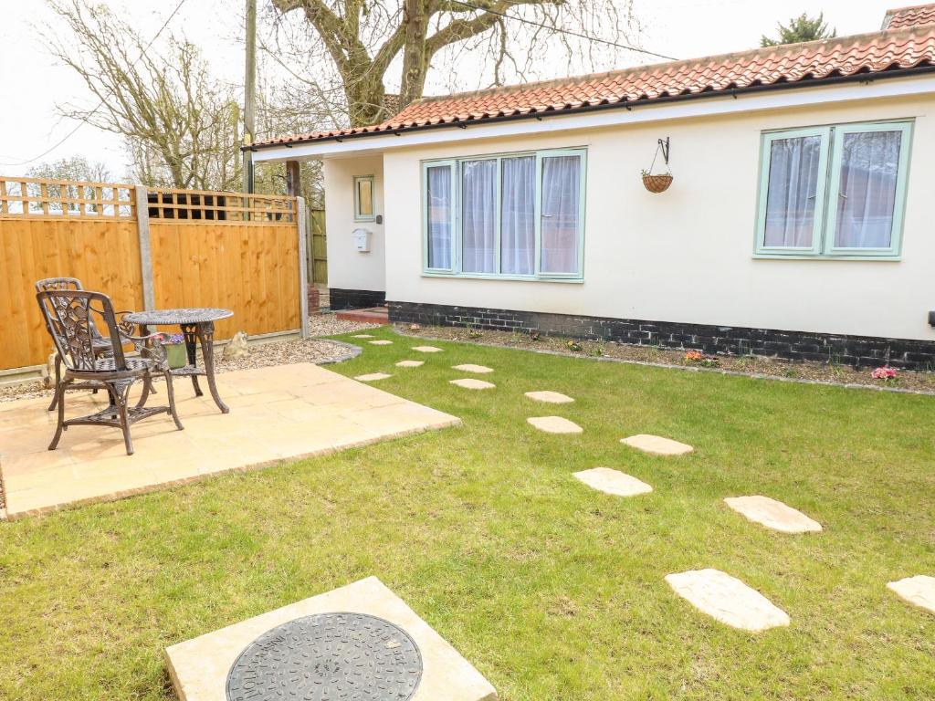 a garden with a table and a chair in a yard at Jimmys Place in Diss