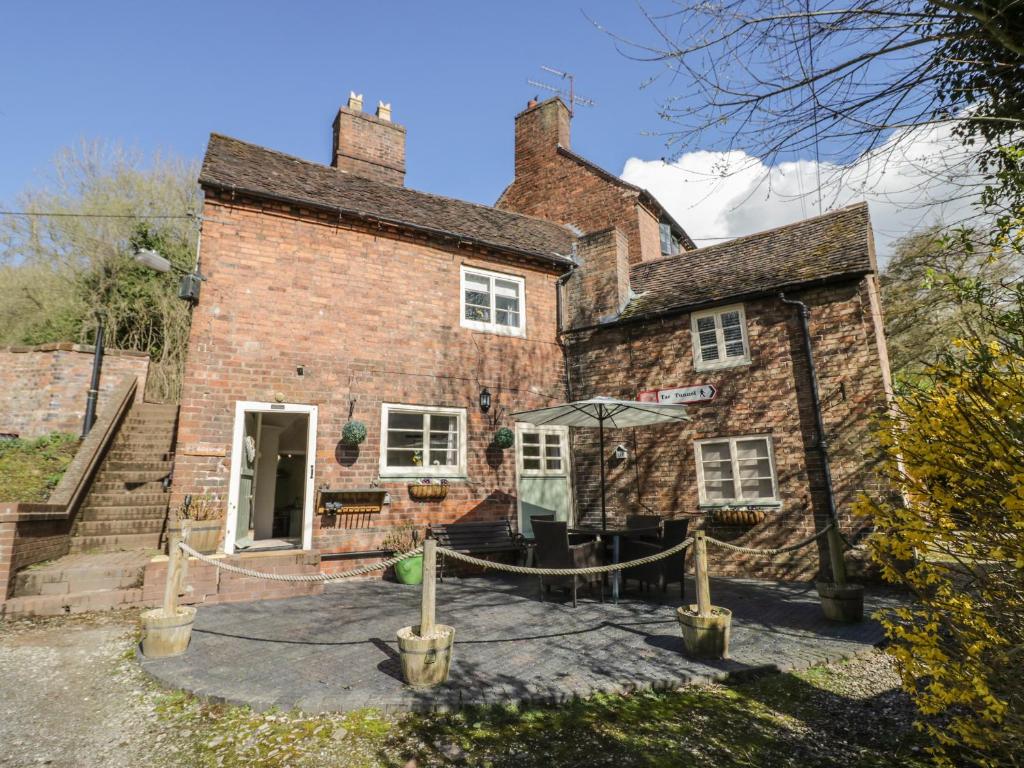 an old brick house with a rope around it at Canal Cottage in Coalport