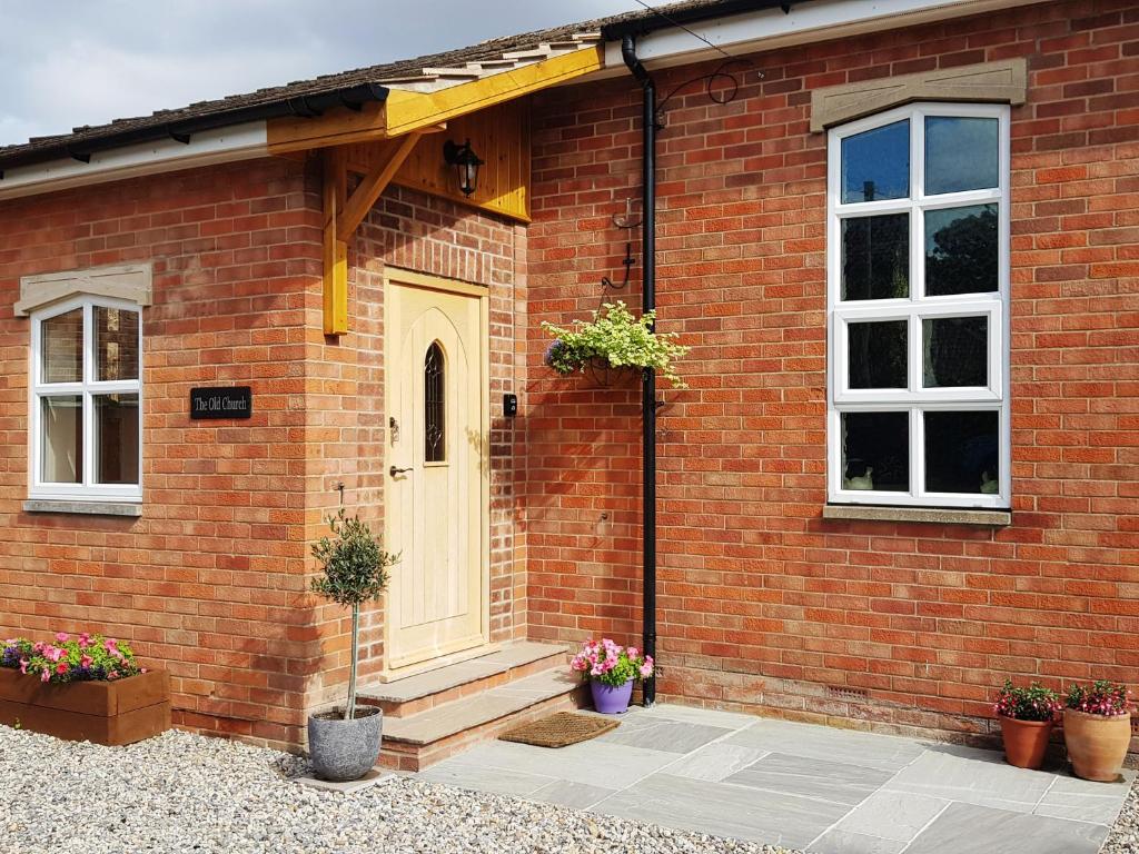 a brick house with a white door and two windows at The Old Church in York