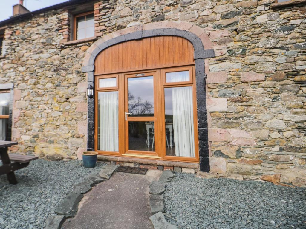 un edificio de piedra con una gran puerta de madera en Daisy Cottage, en Penrith