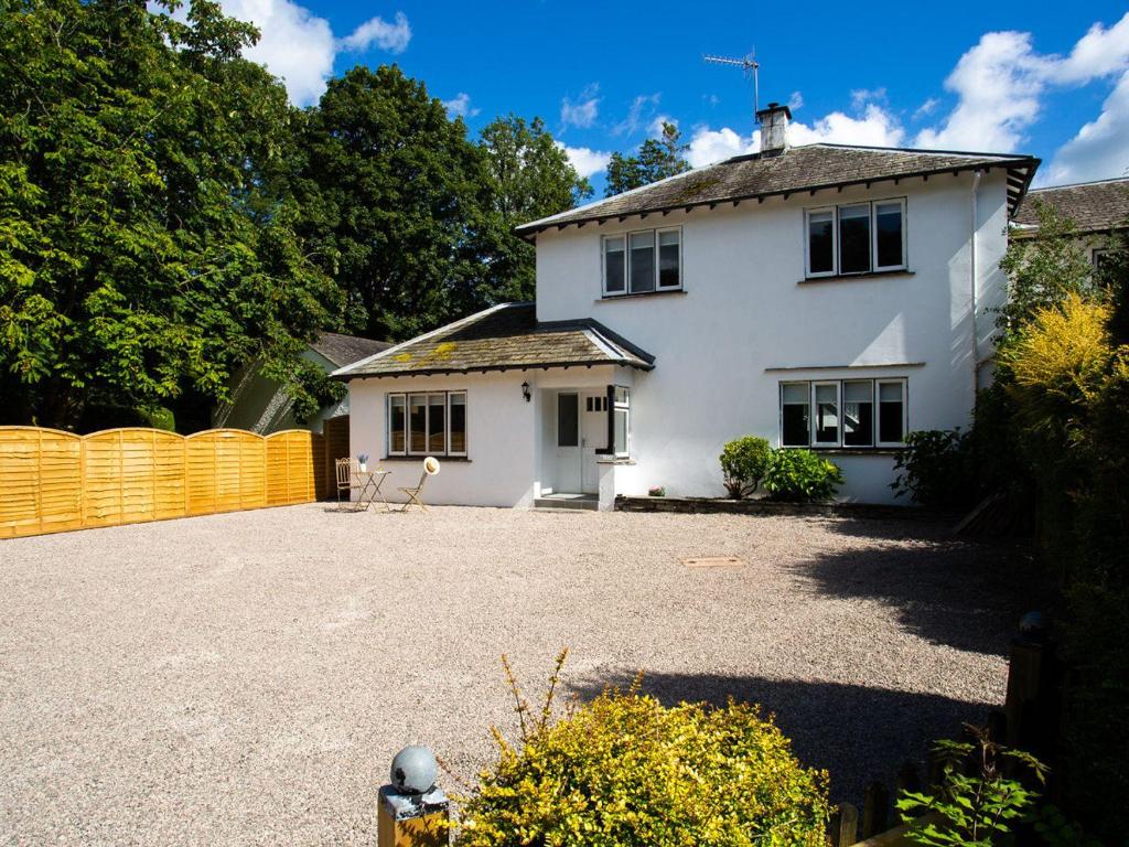 a white house with a driveway in front of it at Bellman Cottage in Windermere