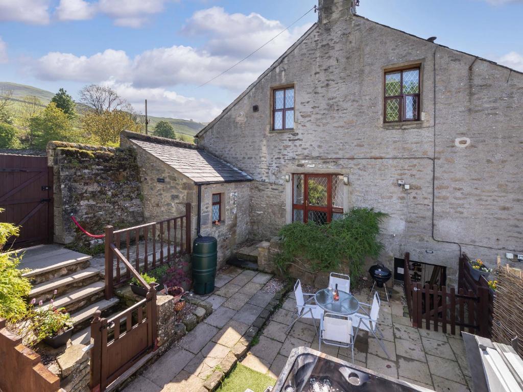 an old stone house with a table and chairs at Ramblers Retreat in Settle