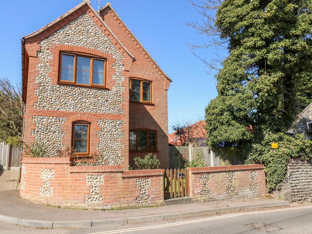 a brick house on the side of a street at Flintstone Cottage in Norwich