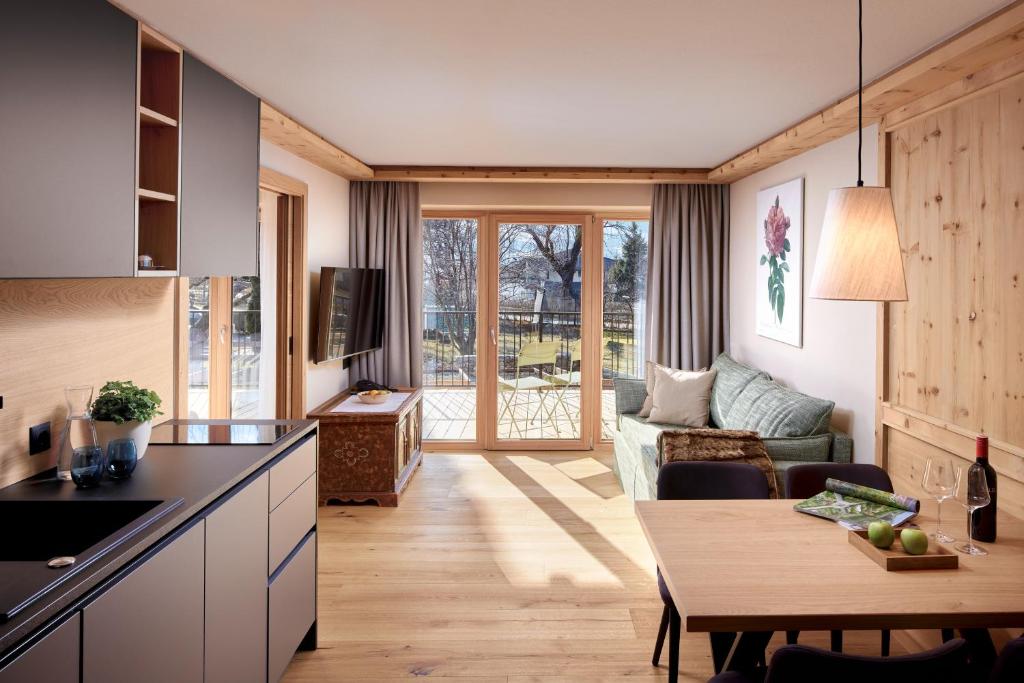 eine Küche und ein Wohnzimmer mit einer Couch und einem Tisch in der Unterkunft Natur Resort RISSBACHER in Stumm