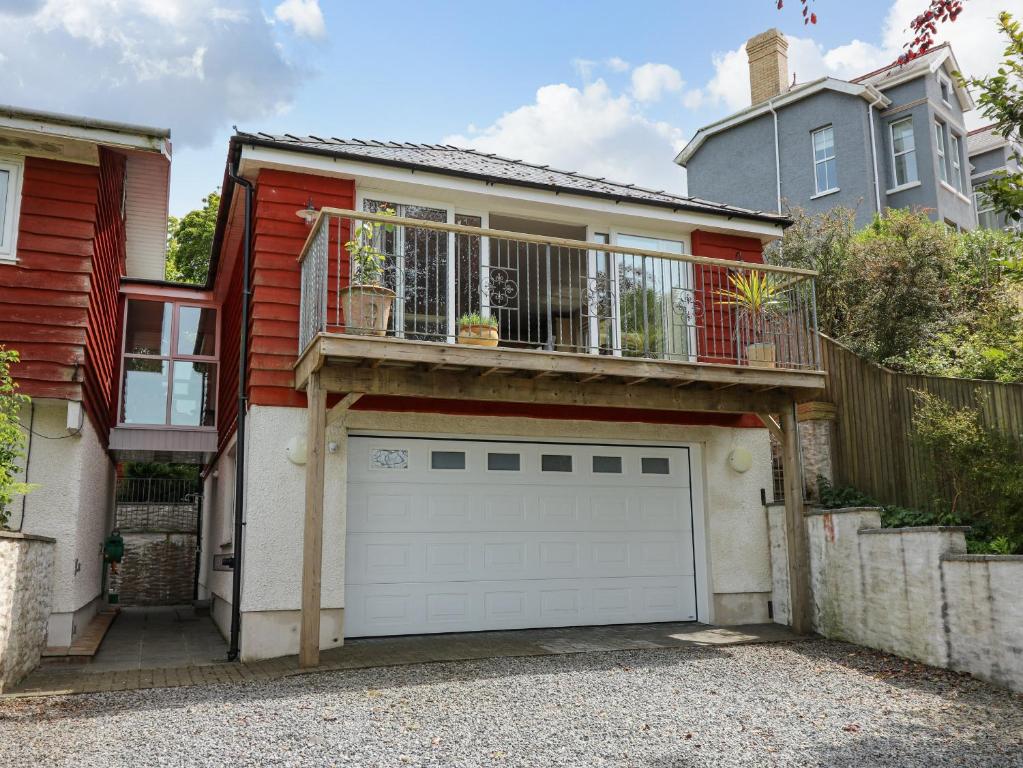 Casa roja con garaje y balcón en Cwmberwyn, en Cardigan