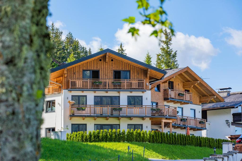 a large wooden house with a balcony at Kirchgassers Landhäusl in Ramsau am Dachstein