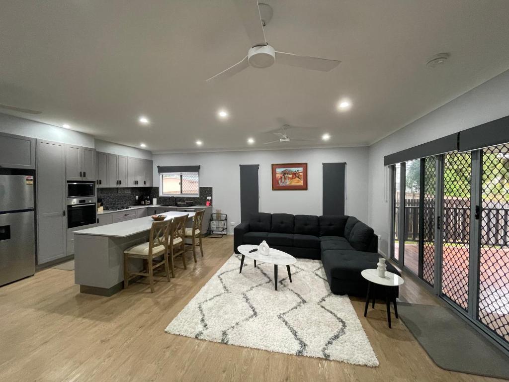 uma sala de estar e cozinha com um sofá e uma mesa em Spacious 4 Bedroom House em Townsville