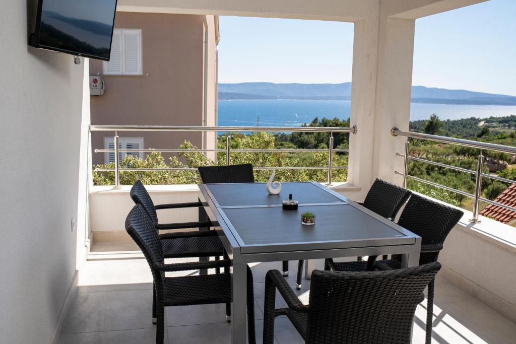 einen Tisch und Stühle auf einem Balkon mit Meerblick in der Unterkunft Olive & Almond Apartment in Bol