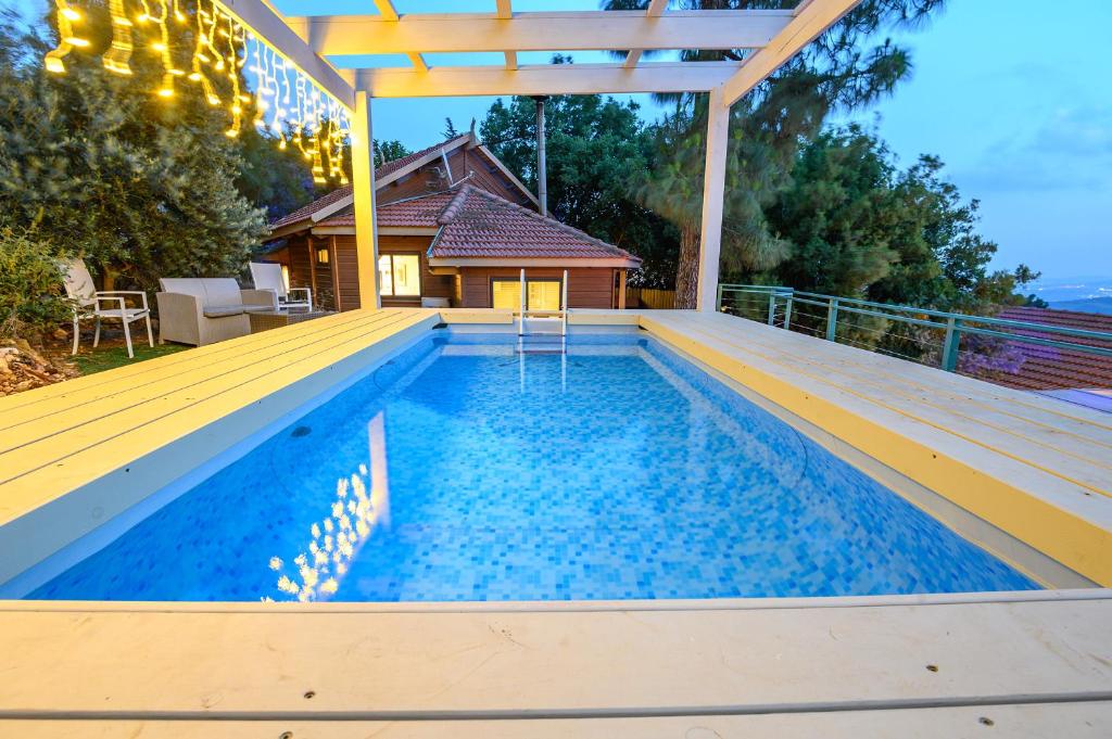 a swimming pool with a pergola on a house at Dream Time in Amirim
