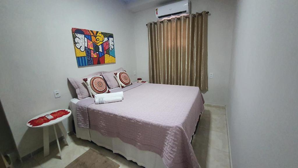 ein Schlafzimmer mit einem Bett und einem Wandgemälde in der Unterkunft Hospedagem da Almira - Apartamento 2 in Manaus