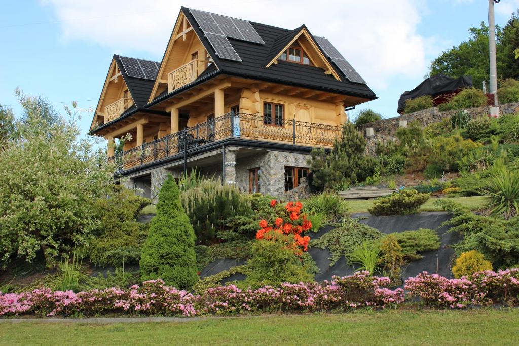 uma casa com painéis solares no telhado em Gazdówka em Bartkowa-Posadowa