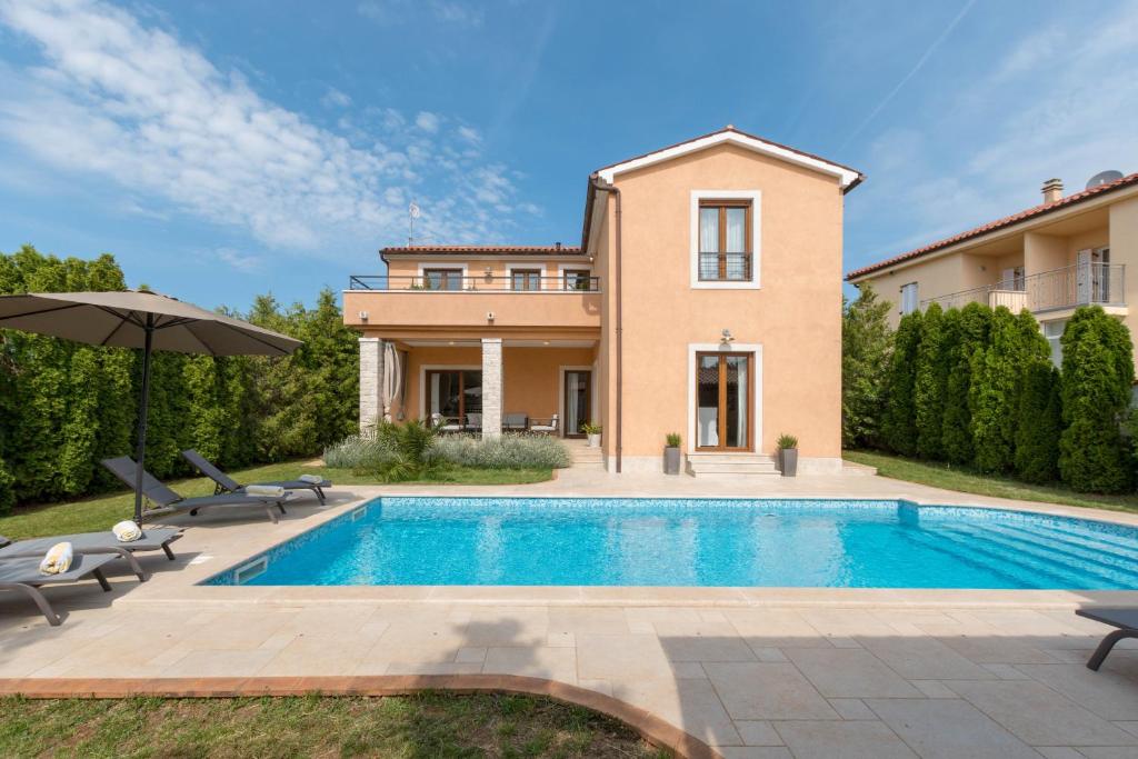een villa met een zwembad en een huis bij Villa Island View in Krnica