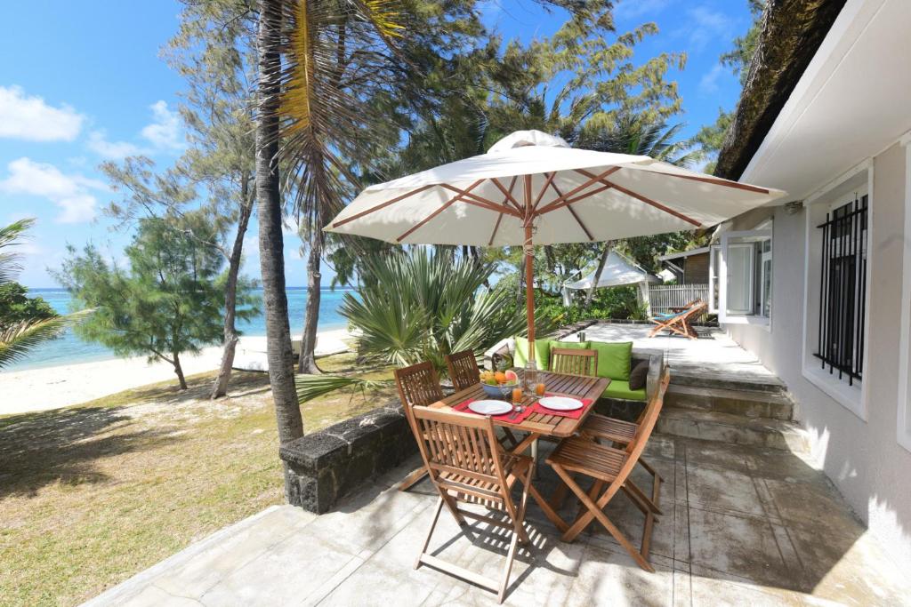 a table and chairs under an umbrella on a patio at Villa Veloutier Blanc in Blue Bay