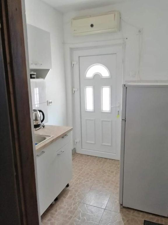 a kitchen with a white door and a refrigerator at Apartment’s Maric - Zelenika,Herceg Novi in Zelenika