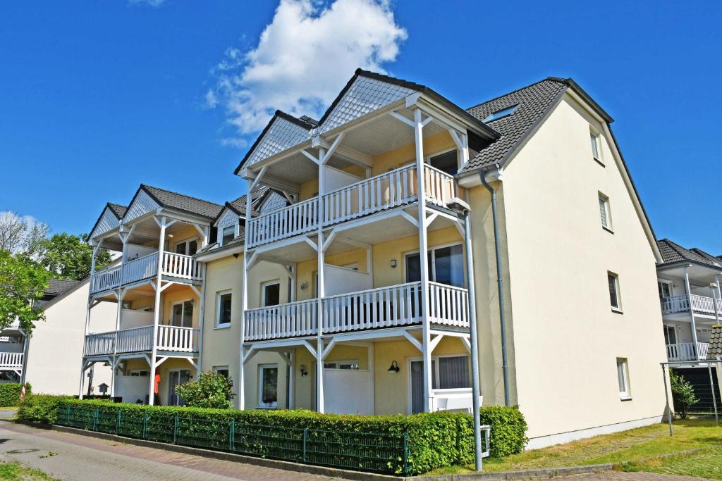 a large white apartment building with balconies at Ferienwohnung mit Balkon am Mönchgraben in Baabe